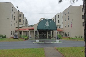 A multi-story building with an arched entrance and green awning.