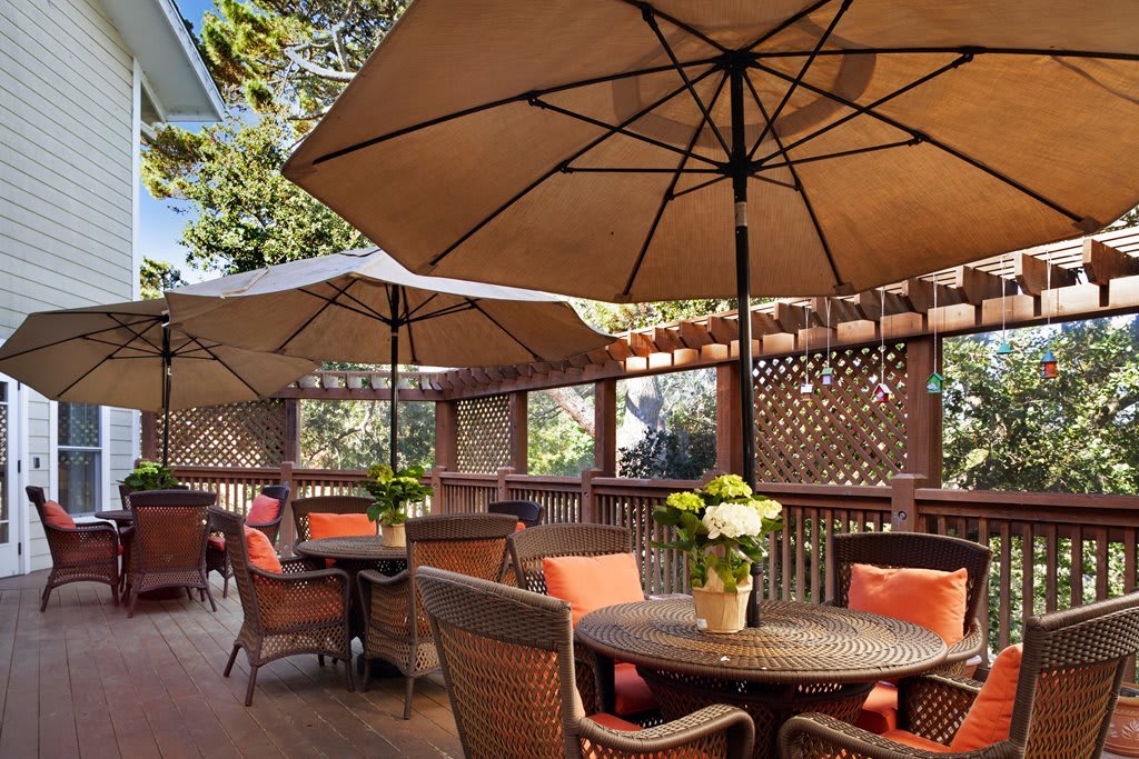 An inviting outdoor patio with tables and chairs beneath large umbrellas, perfect for a relaxing meal.