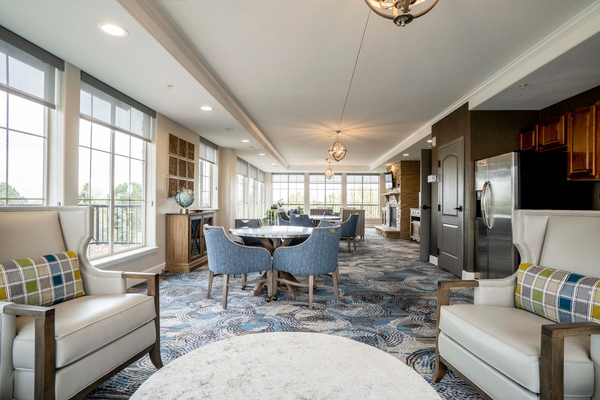 A modern and elegant living room with ample seating, featuring large windows that allow for abundant natural light.
