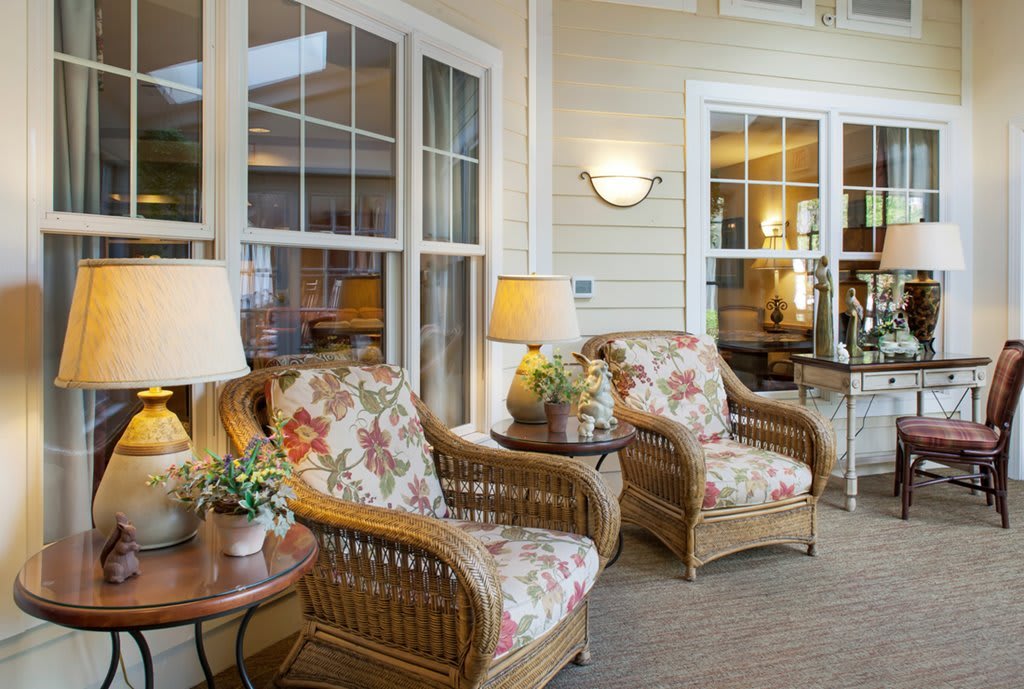 A cozy living room with floral armchairs and natural light.