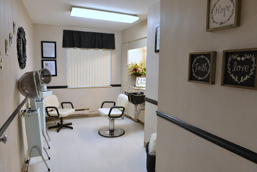 A cozy and well-lit salon waiting area with stylish chairs and floral decor.
