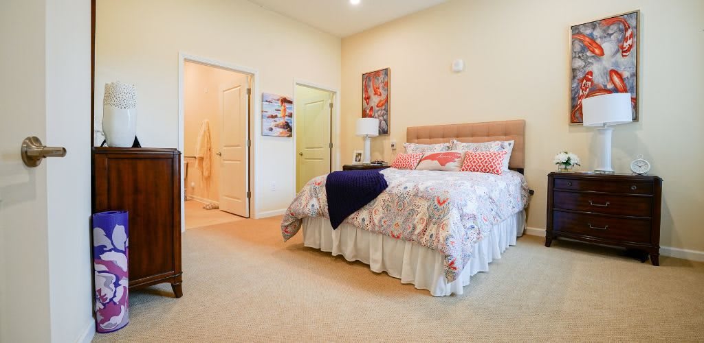 A cozy bedroom with a neatly made bed, soft lighting, and warm decor.