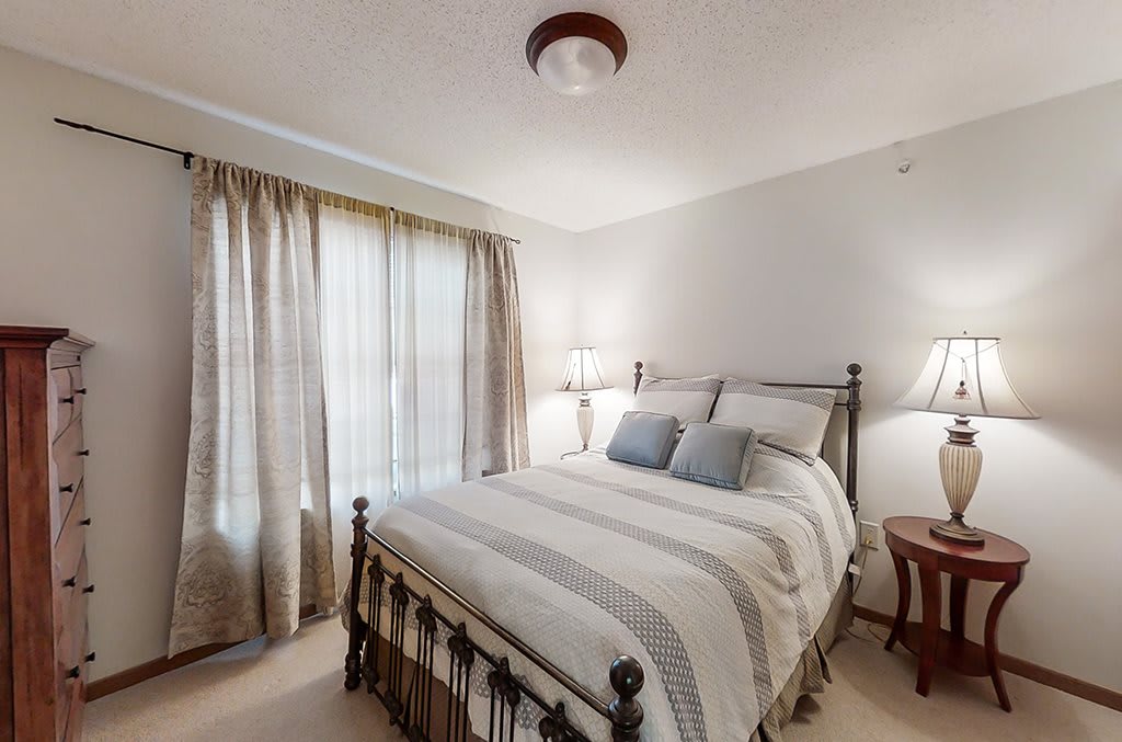 A cozy bedroom with a neatly made bed and soft lighting.