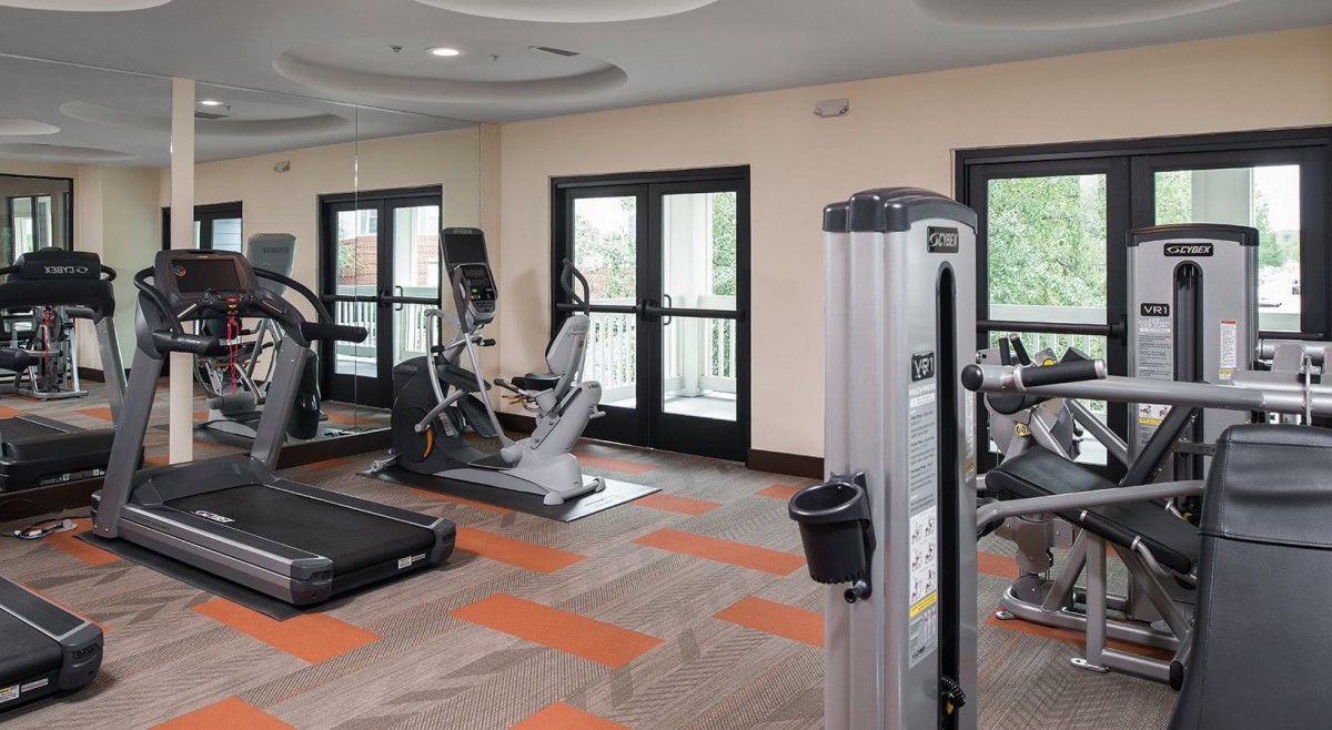A well-equipped gym with exercise machines and a modern interior.