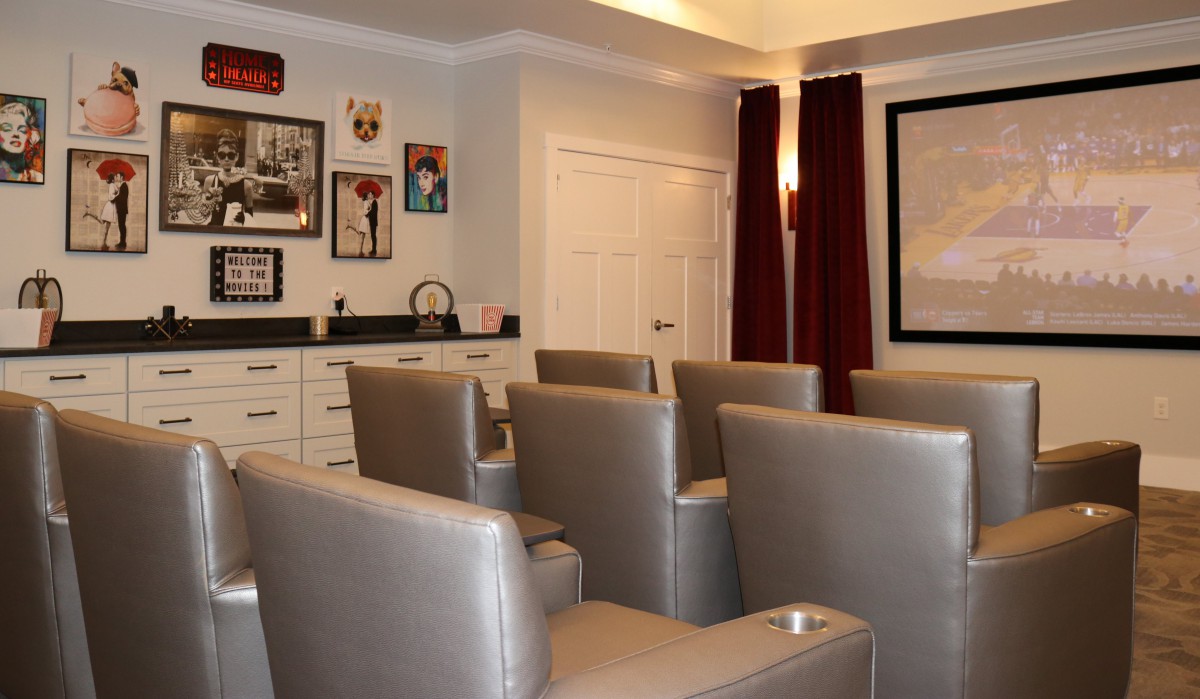 A cozy home theater with comfortable seating and wall art.