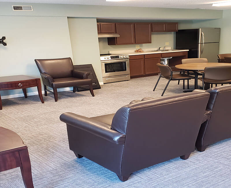 A cozy living room with a connected kitchen area featuring modern furniture and appliances.