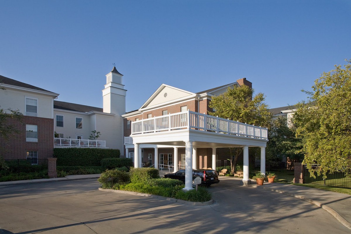 A building with a covered driveway and balcony.