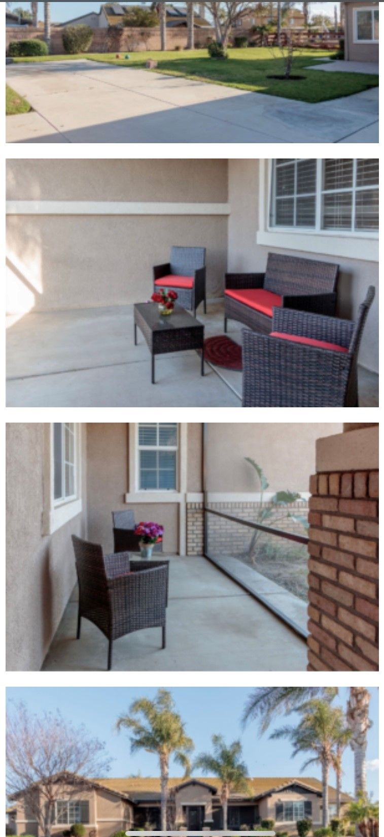 A cozy outdoor patio featuring wicker furniture with red cushions and a small table adorned with flowers.