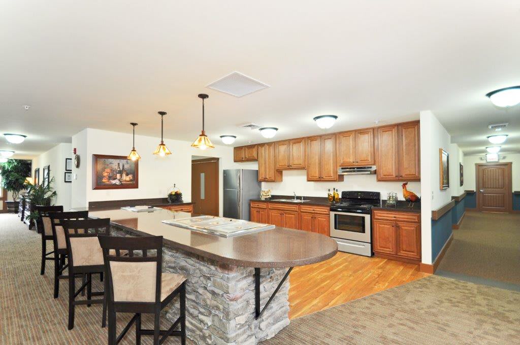 A modern kitchen with wooden cabinets, a central island, and stainless steel appliances.