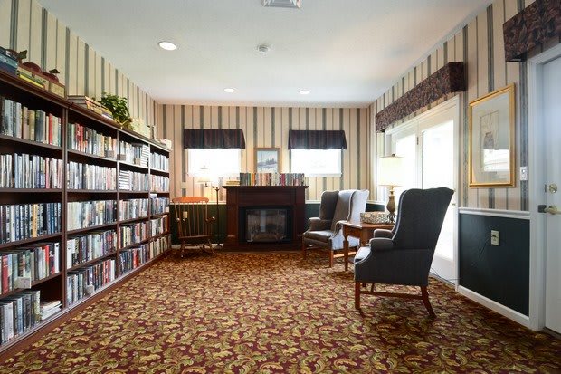 A cozy library reading room with bookshelves and comfortable seating.