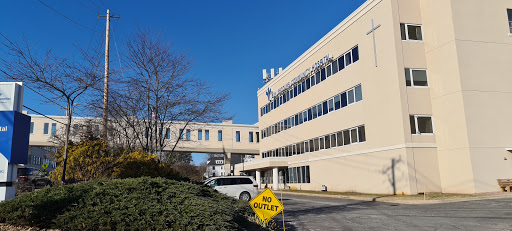 A hospital building with a connecting bridge under a clear blue sky.
