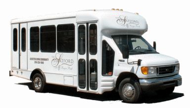 A white shuttle bus with logo and tinted windows.