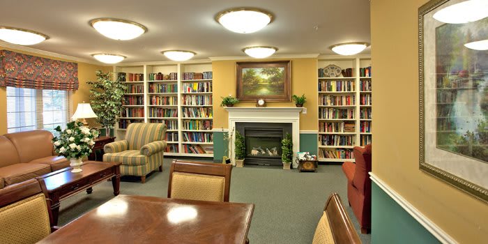 A cozy library with shelves full of books and a fireplace.
