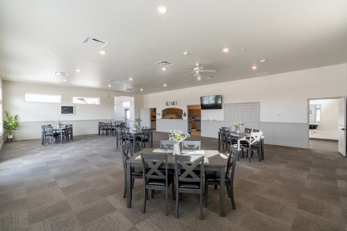 A modern dining area with neatly arranged tables and chairs under bright indoor lighting.