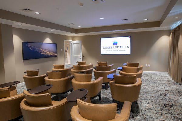 A conference room with rows of chairs facing a presentation screen.