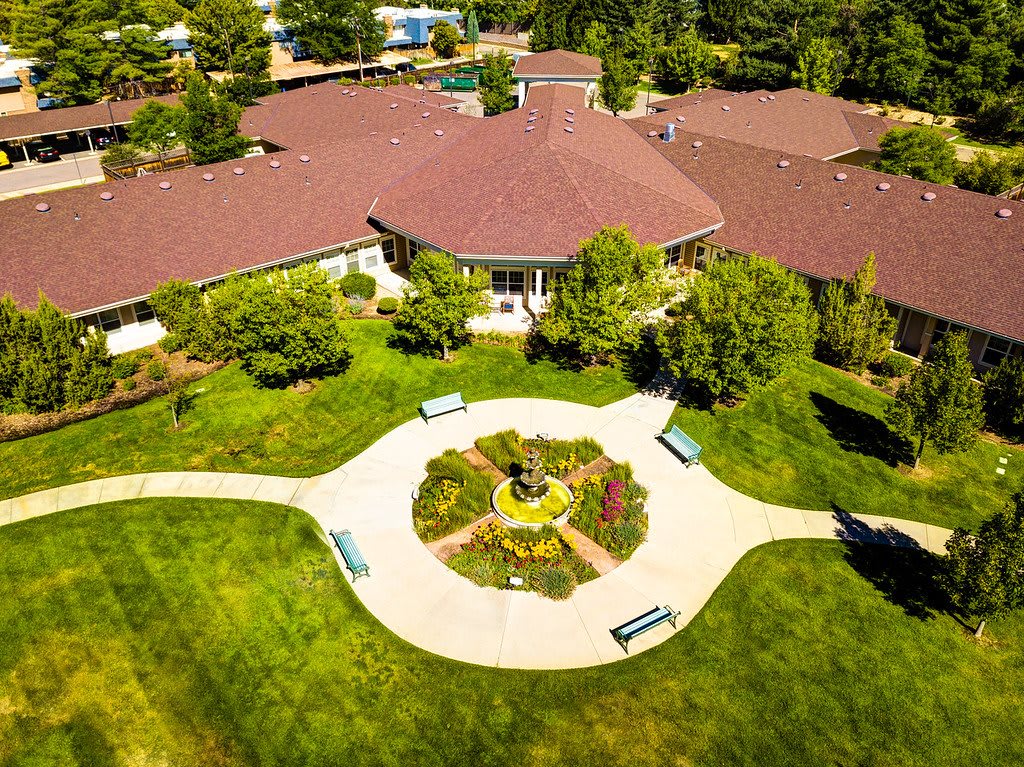 Aerial view of a landscaped garden with pathways and a central building surrounded by greenery.