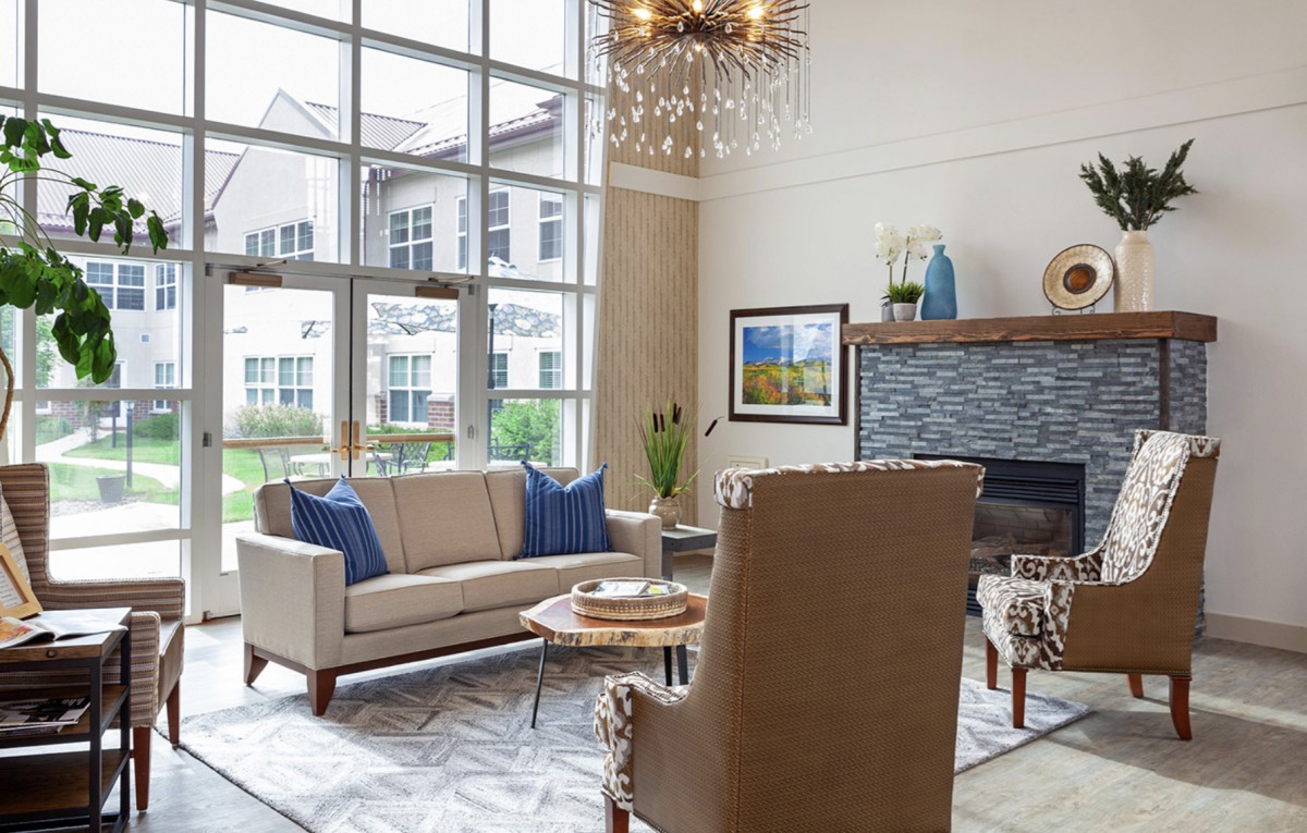 A modern living room with a cozy seating arrangement and large windows.