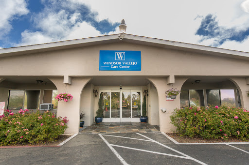 The entrance of a professional office building, featuring clear signage and landscaped surroundings.