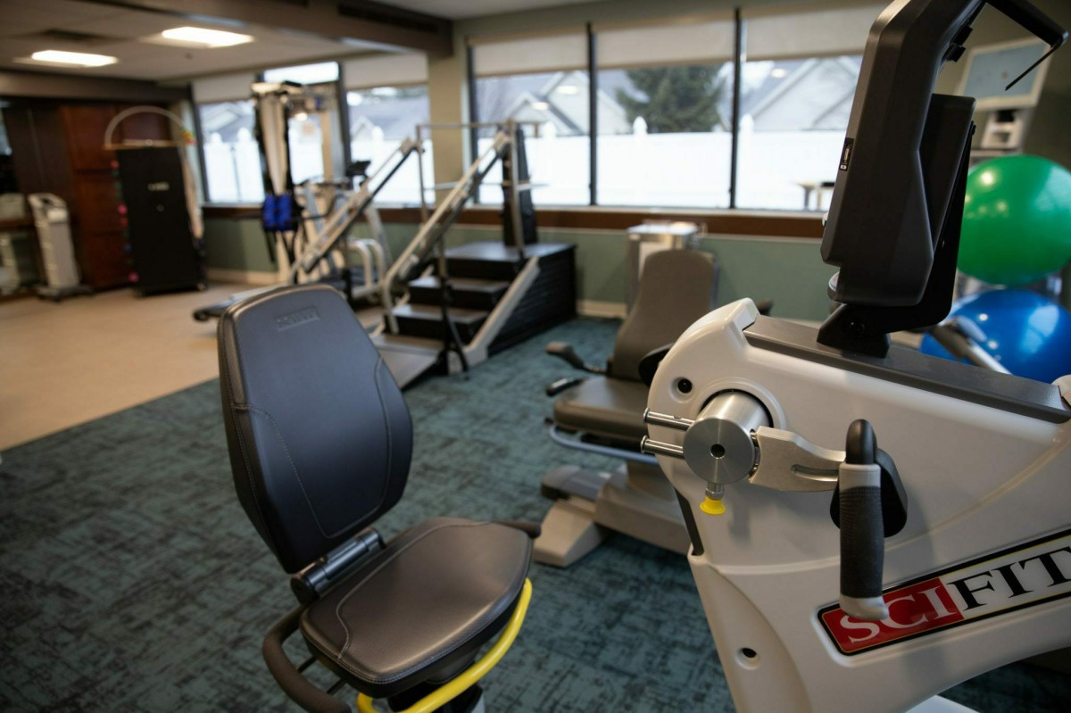 An indoor gym with various exercise equipment and machines.