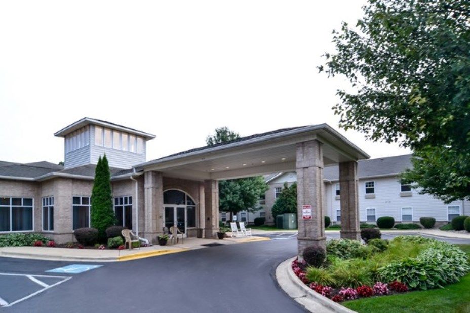 A welcoming entrance with a covered driveway and landscaped surroundings.