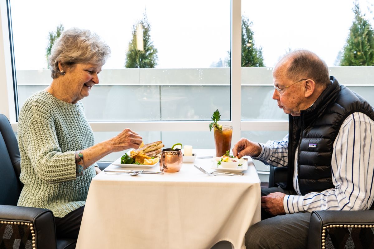 An elderly couple enjoying a meal together at a restaurant.