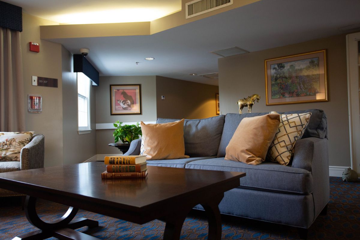 A cozy living room with a comfortable sofa adorned with cushions, a wooden coffee table, and wall art enhancing the decor.