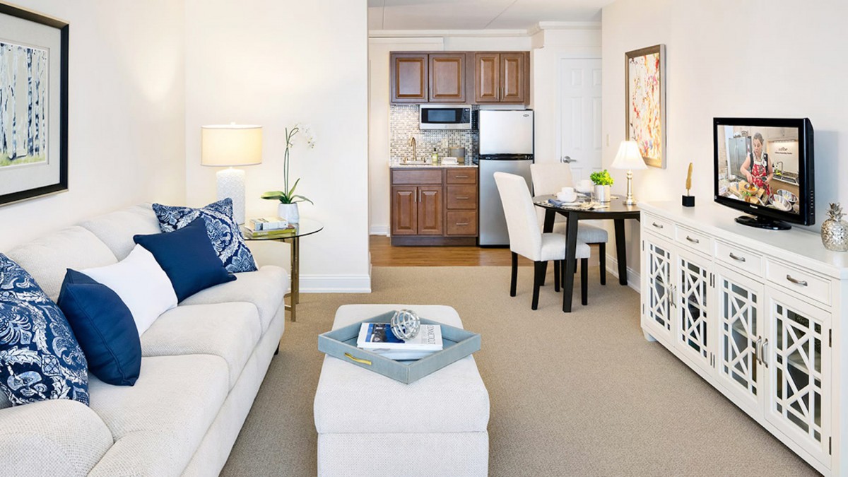 A modern apartment with a cozy living room, compact kitchen, and dining area.