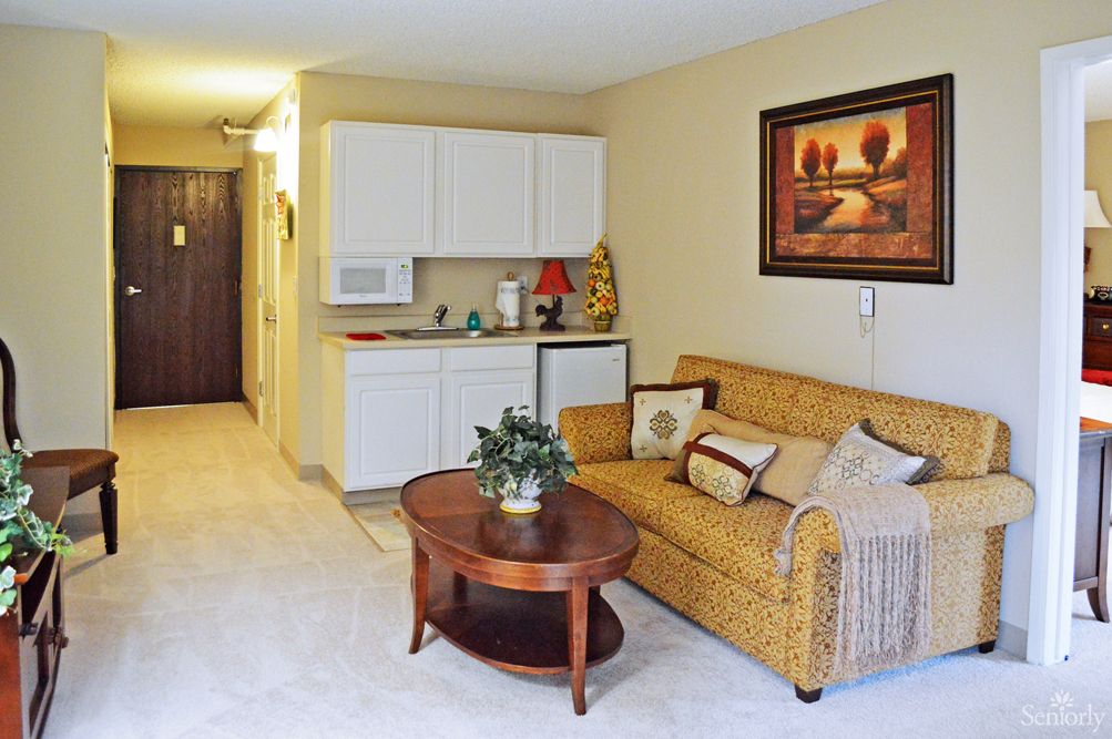 A cozy living room with a comfortable sofa, coffee table, and decorative wall art.