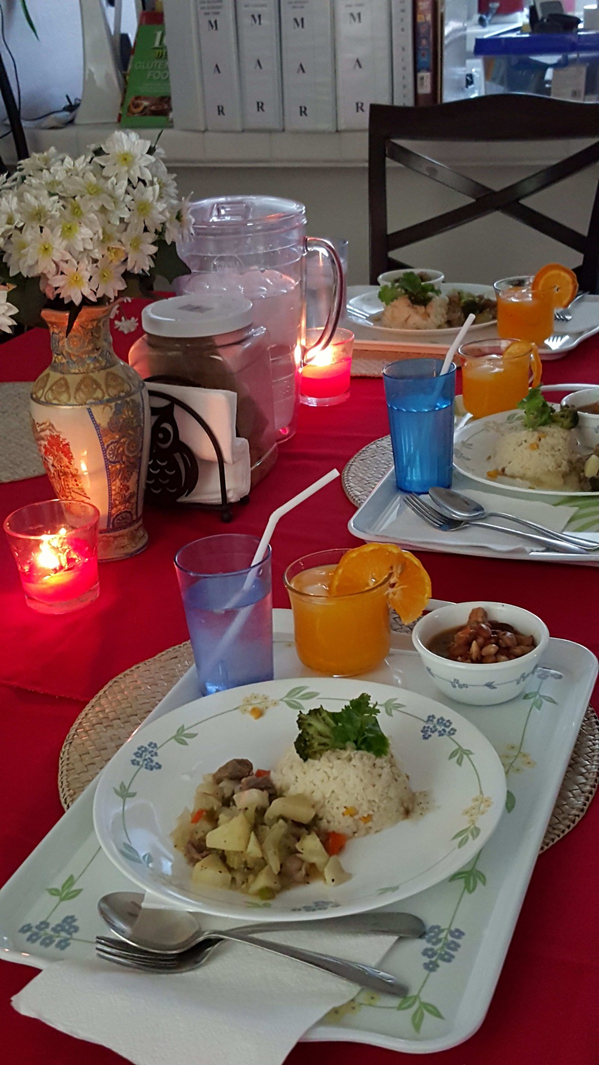 A beautifully set dining table with a rice dish, juice, and candles for an intimate meal.