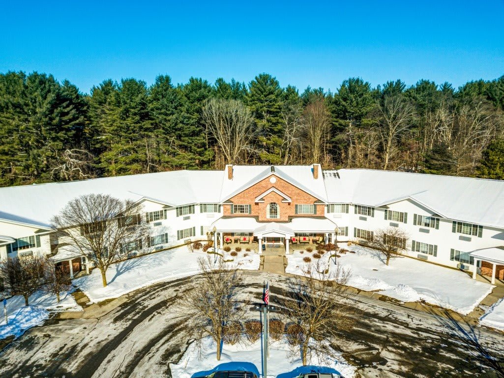 Aerial view of a building surrounded by snow and trees in winter.