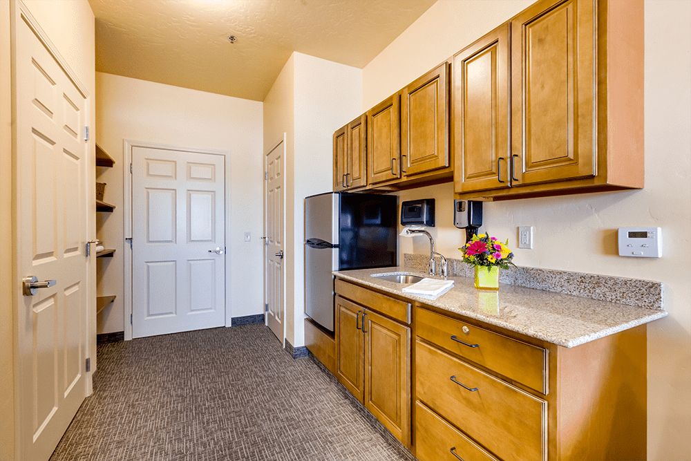 A small, modern kitchen with wooden cabinets and stainless steel appliances.