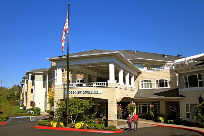 A well-maintained retirement home with a welcoming entrance and a flagpole.