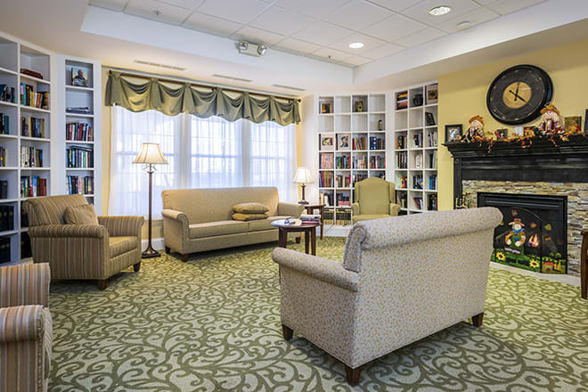 A cozy living room with sofas, a bookshelf, and elegant lighting.