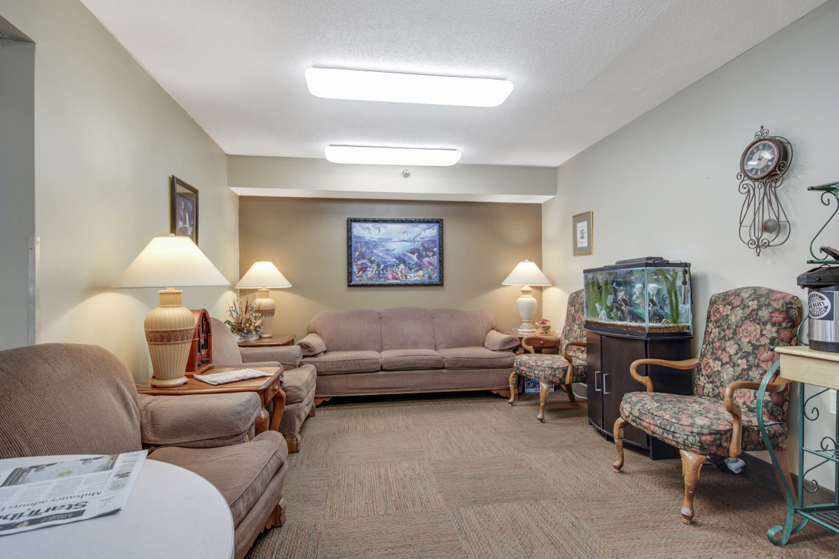 A cozy living room with comfortable seating, warm lighting, and a fish tank.