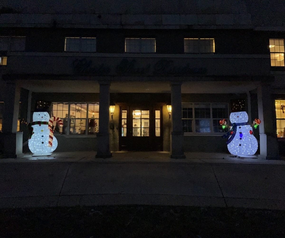 Festive outdoor Christmas display with illuminated snowmen at night.