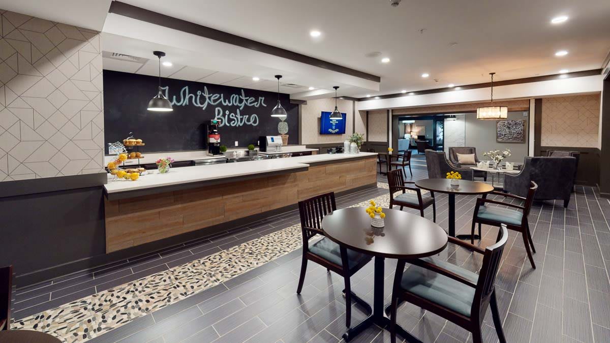 A modern cafe interior with a seating area and a chalkboard menu.