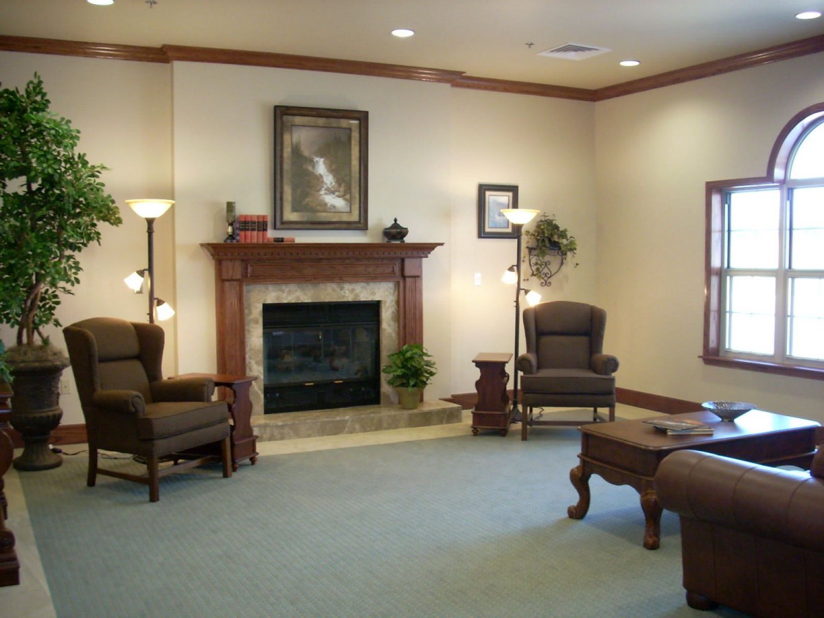 A cozy living room featuring a fireplace, comfortable chairs, and elegant decor.