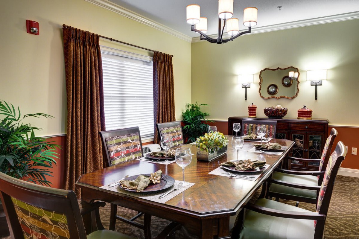A warmly lit dining room with a set table and elegant decor.