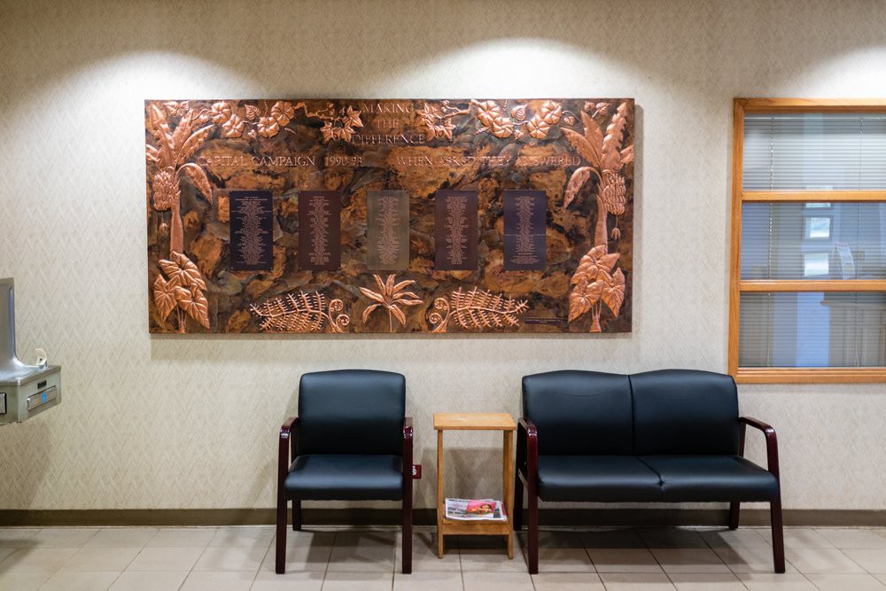 An empty waiting area with chairs and a small table, adorned with decorative wall art.