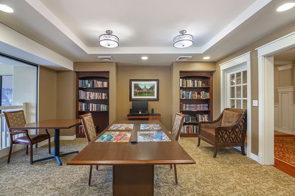 Cozy library room with bookshelves and a wooden table for reading.
