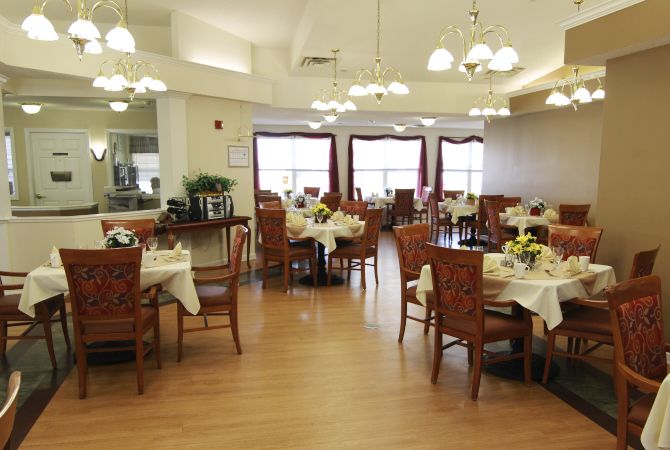An elegant dining area with neatly arranged tables and chairs under soft lighting.