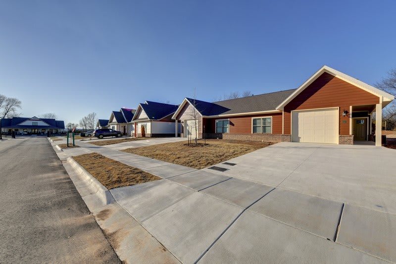 A quiet suburban neighborhood street lined with single-story houses and driveways.