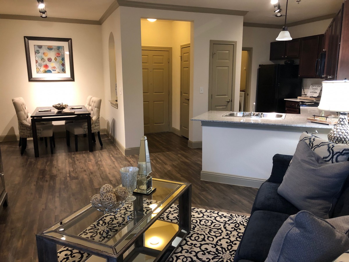A modern apartment featuring a cozy living room with stylish furniture, an open kitchen, and a dining area.