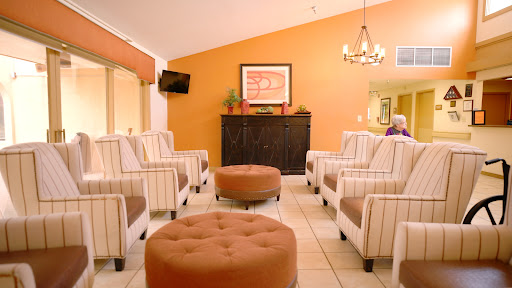 A cozy lounge area featuring striped chairs and a warm orange wall.