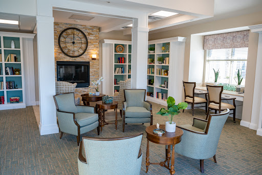 A cozy reading lounge featuring comfortable seating, bookshelves filled with books, and a warm atmosphere.