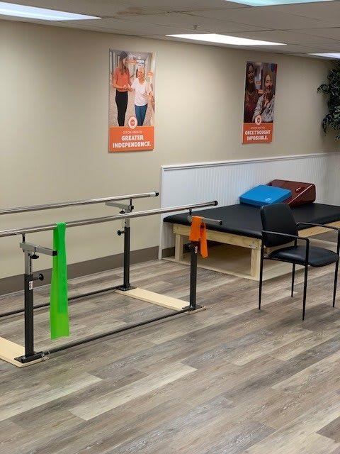 A physical therapy room featuring parallel bars and exercise bands for rehabilitation.