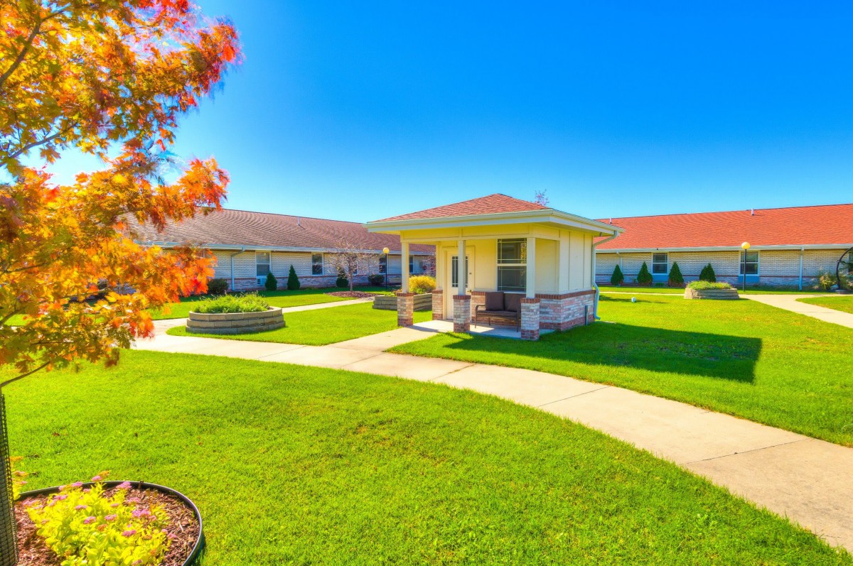 A beautiful house with a lush garden and clear blue skies.