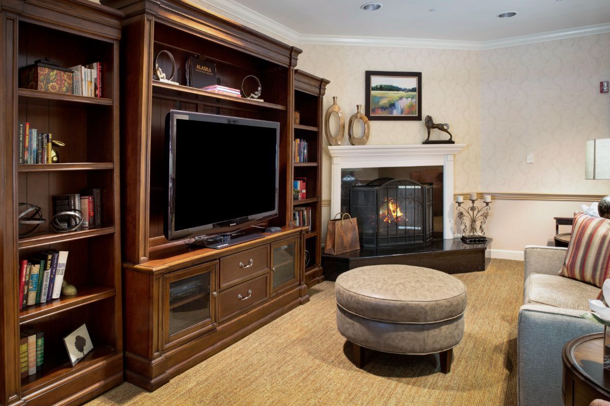 A cozy living room featuring a fireplace, entertainment center with a television, and comfortable seating.