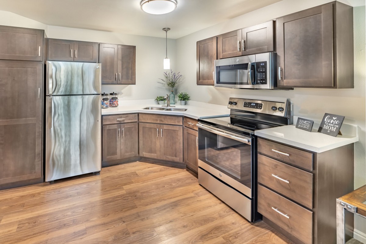 A modern kitchen with stainless steel appliances and wooden cabinets.