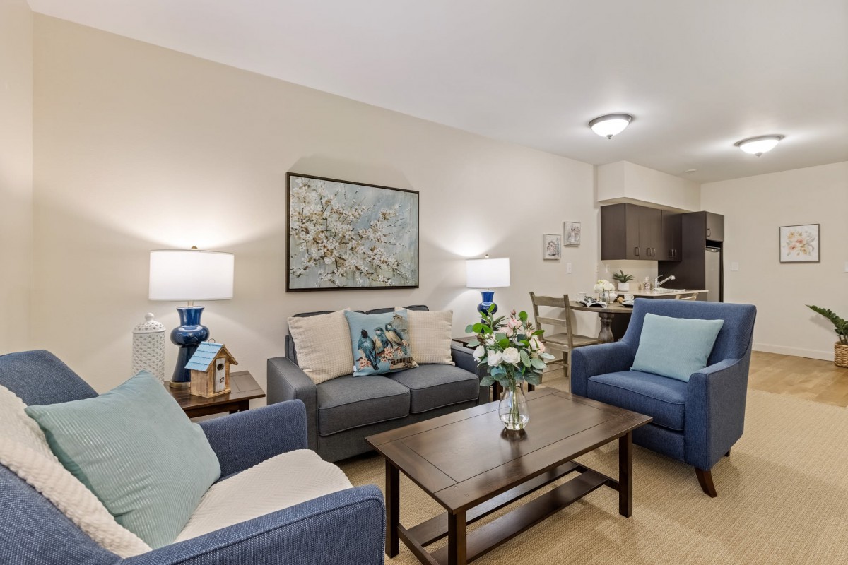 Cozy living room with blue and neutral-toned furniture, adorned with artwork and decorative elements.
